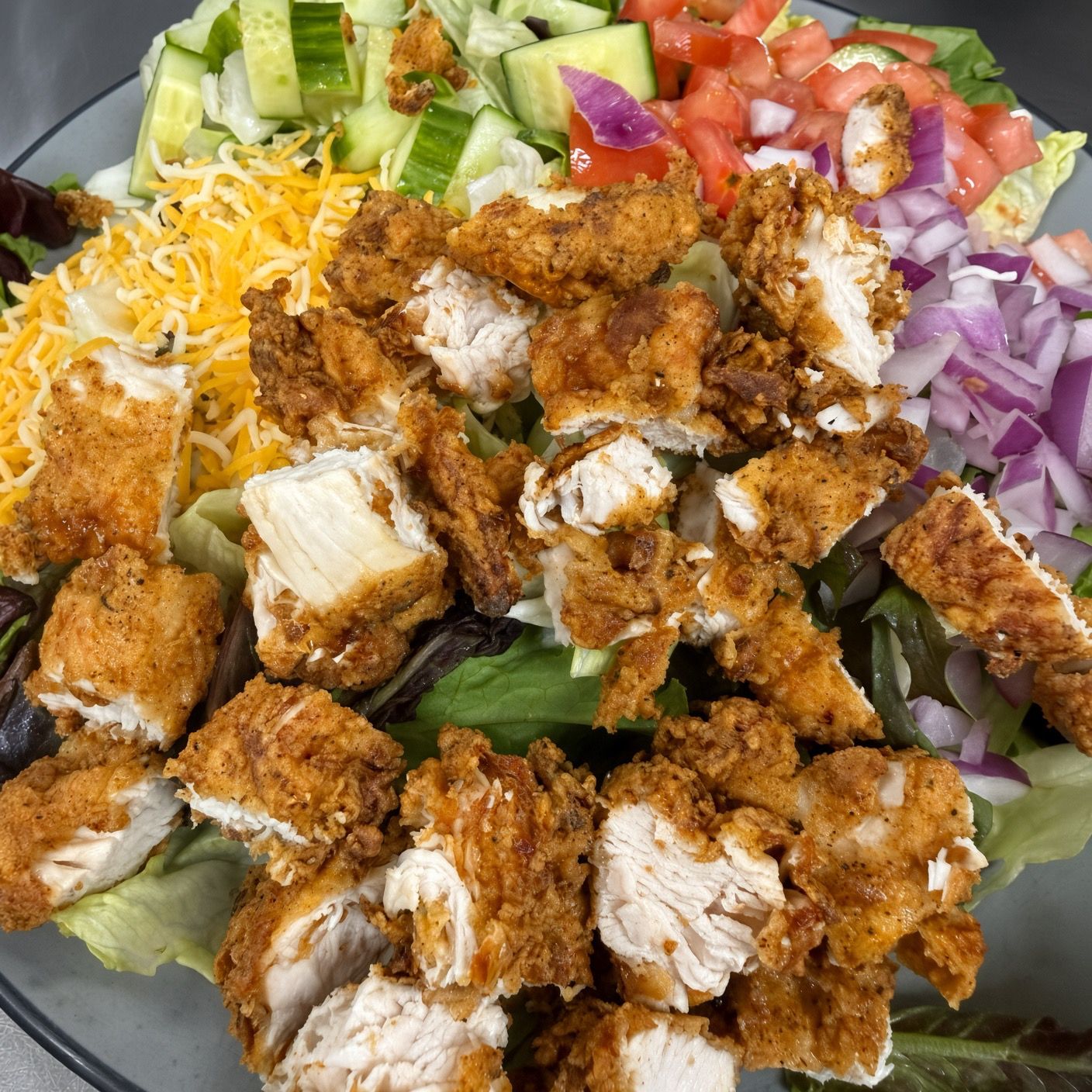 Crispy chicken salad with cheddar, cucumber, tomato & red onion