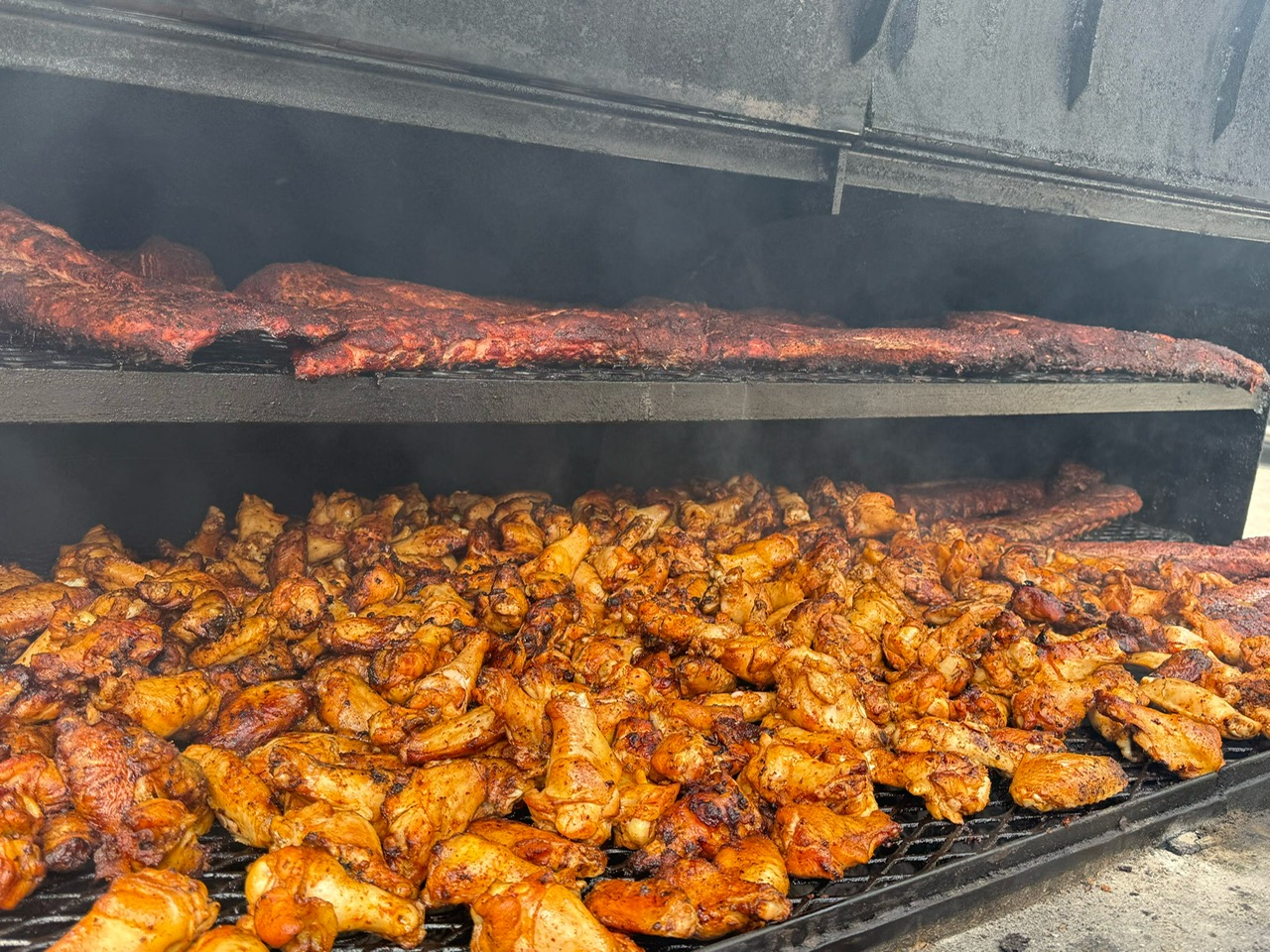 Racks of ribs and wings on the smoker
