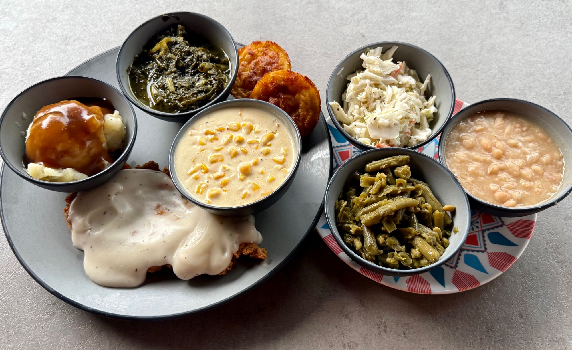 Meat & three spread with country fried chicken and southern sides